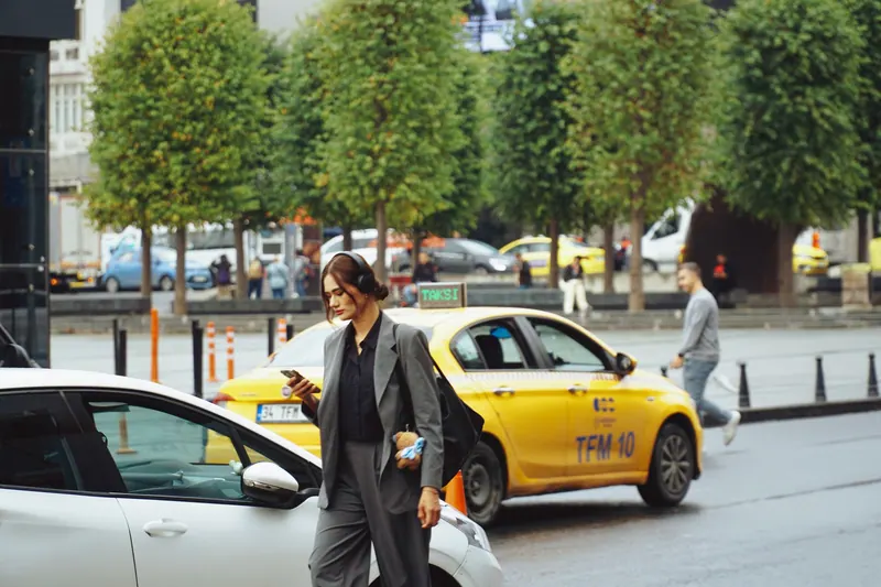 Geschäftsfrau im Taxi mit Blick aufs Smartphone