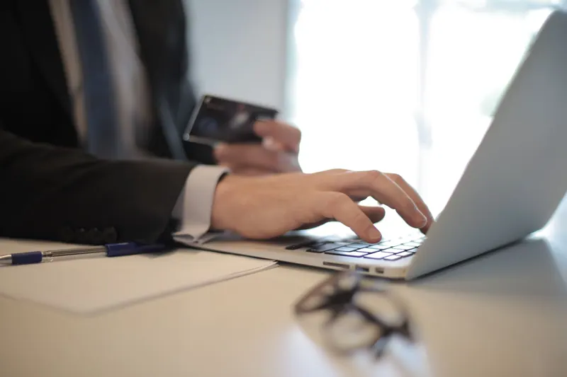 Mehrere Firmenkarten ohne Beschriftung auf einem Schreibtisch neben einem Laptop