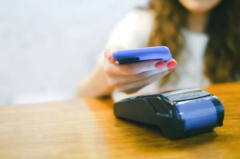 Mobiles Bezahlen mit dem Smartphone an einer Cafétheke