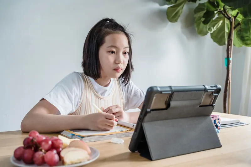 Person vergleicht Optionen auf einem Tablet am Schreibtisch